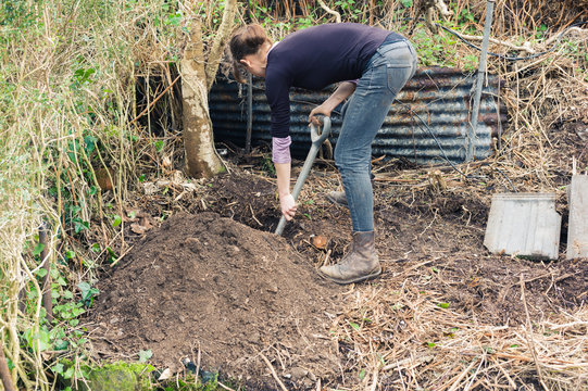 Young woman digging hole in garden