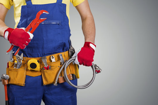 plumber with tool belt isolated on gray with copy space