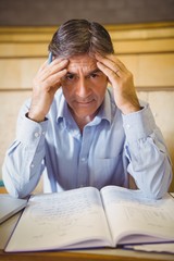 Naklejka premium Portrait of depressed professor sitting with notes