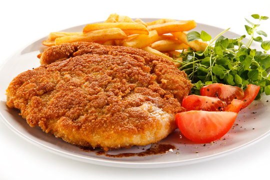 Fried pork chop, French fries and vegetables 