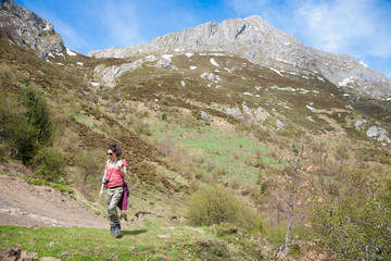 Fototapeta premium woman trekking down rocky peak