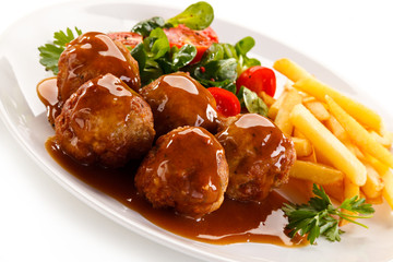 Roasted meatballs, chips and vegetables 