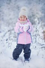 Cute little girl in the winter forest