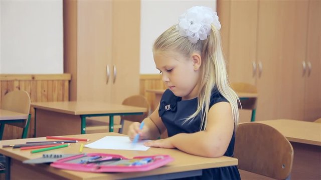 The girl draws in the classroom