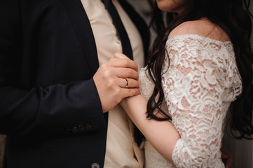 Obraz na płótnie Canvas Bride and groom holding hands close up