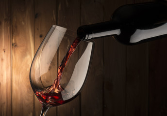 glass with red wine on wooden background