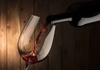 Afwasbaar Fotobehang Wijn glas met rode wijn op houten achtergrond