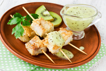 Fish kebabs on bamboo skewers with light kiwi sauce