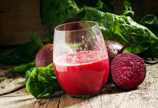 Large glasses with red beet juice, fresh beetroot with tops, vin