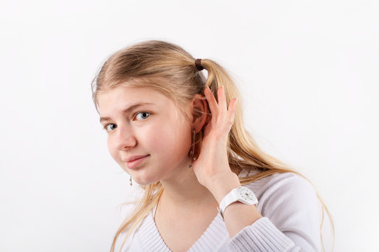 Young beautiful woman cant hear you so she cupping hand behind ear