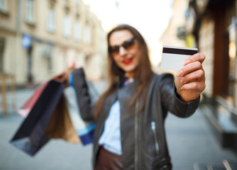 Happy beautiful woman with shopping bags and credit card in the