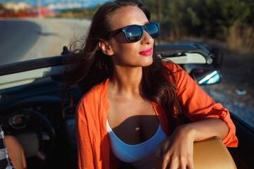 Beautiful woman sitting in cabriolet, fashionable lifestyle conc