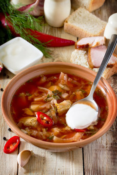 Vegetable soup with beetroot (borscht) on a wooden table, the na