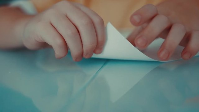 a little boy makes a paper plane