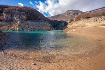 The beach of the lake and a blue sky with clouds