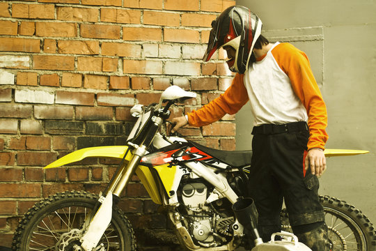 Caucasian man examining dirt bike