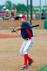 Cute baseball player holding a bat.