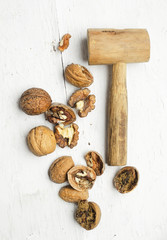 Cracked walnuts and wooden hammer