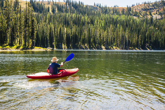 Caucasian man rowing canoe on remote lake