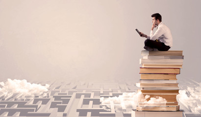 Man with tablet sitting on books