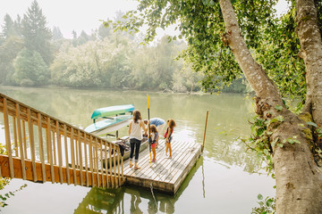 Family standing on dock in lake