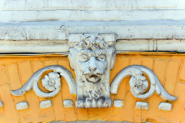 decorative sculpture in the form of a lion's head on the facade of an old building