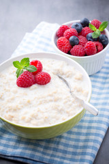 Oatmeal porridge in bowl with berries raspberries and blackberri