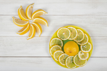 Citrus fruit slices arranged into revolving shape and decorated on a plate in top view.