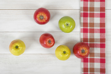 Apples placed on red checkered kitchen tablecloth. Top view.