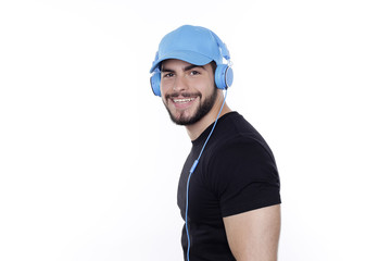 Junger Mann mit blauem Basecap und Kopfhörer lächelt in die Kamera