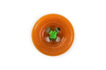 orange button with green thread on white background
