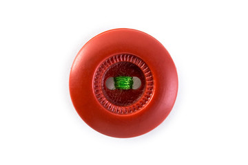 red button with green thread on white background
