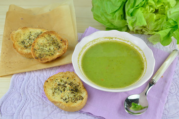 Bowl with fresh green cream soup (pottage) with garlic bread