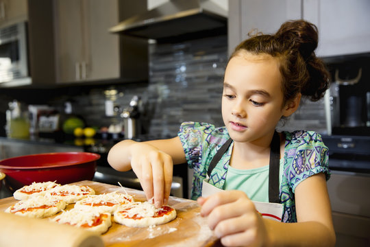 Girl making pizza in the kitchen