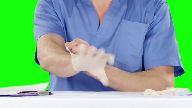 Medical doctor putting on gloves. Green screen