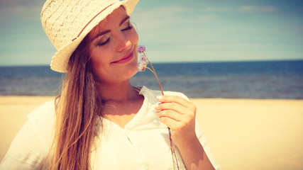 Smiling girl with flower on beach