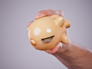 Male hand with coins and piggybank