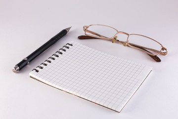 pencil notebook and glasses on a white background