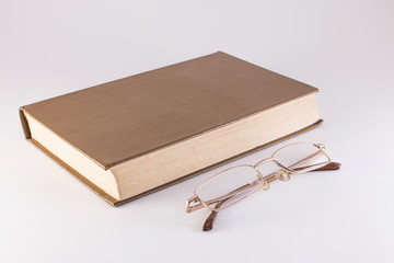 book and glasses on a white background