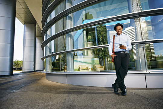 Businessman Using A Cell Phone Outside Office Building