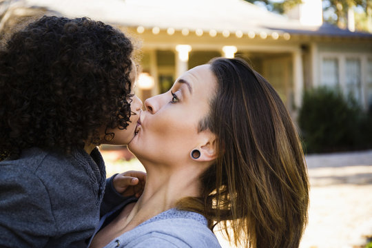 Mother kissing son outdoors
