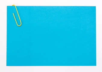 blue sheet of paper with a yellow clip