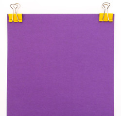 purple sheet of paper with yellow paper clip on a white background