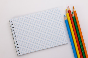 notebook and colored pencils on a white background