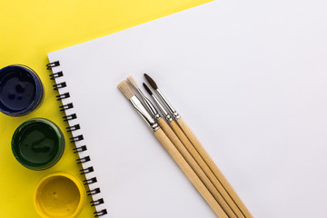 gouache and brushes on a yellow background