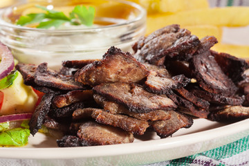 Grilled meat with French fries and fresh vegetables