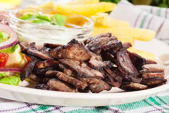 Grilled meat with French fries and fresh vegetables