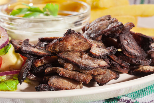 Grilled meat with French fries and fresh vegetables