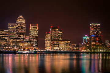 Fototapeta na wymiar London skyline at night seen from across the river Thames, Canary Wharf is London’s financial district a place where the world’s greatest corporation and banks do business