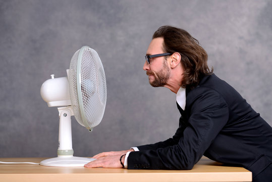 business man in dark suit sitting in front of ventilator